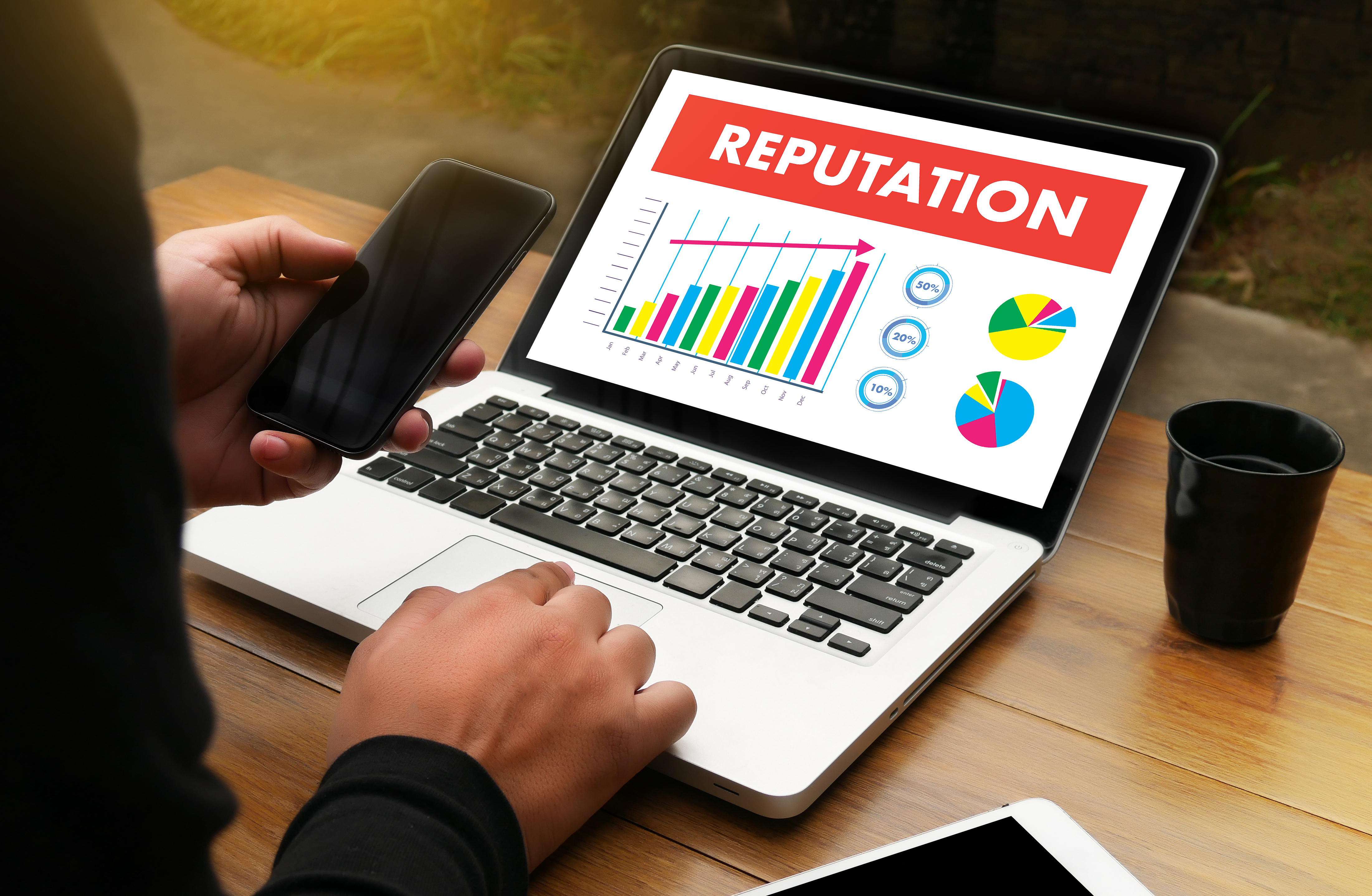 A laptop with a graph and the word 'Reputation' in bold on the screen