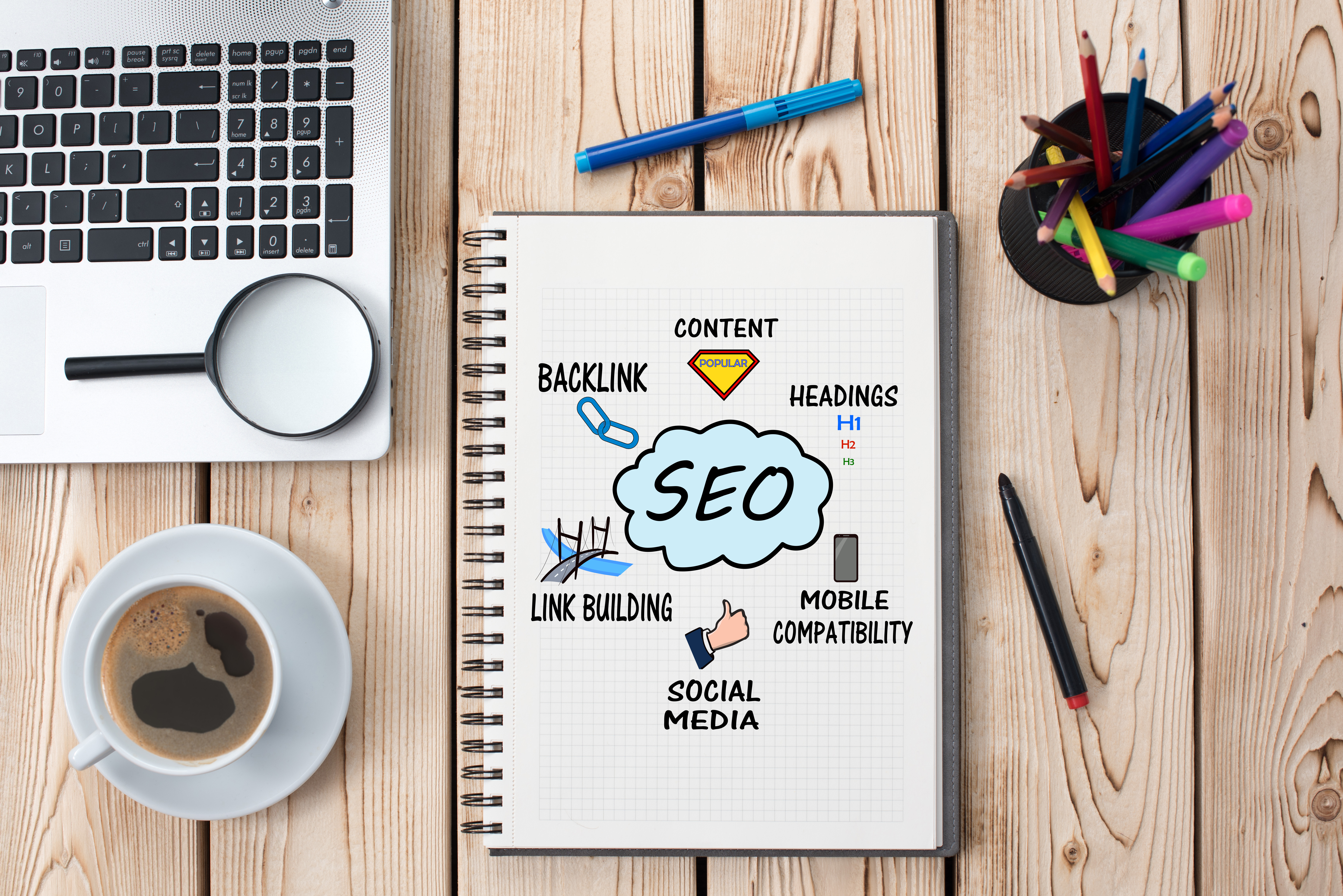 A desk with a sketchbook with SEO ideas written in it